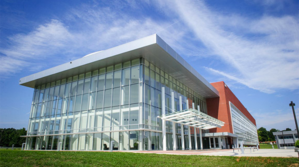 The NC A&T and University of North Carolina Greensboro Joint School of Nanoscience and Nanoengineering building, seen from a low angle on a sunny day.